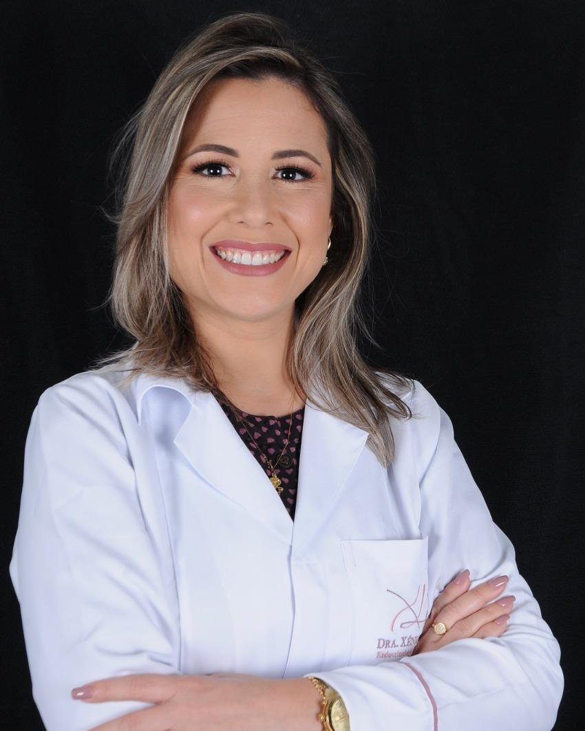 Dra. Xênia Leite, endocrinologista, sorrindo, de jaleco branco